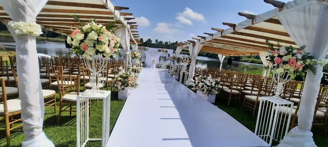 Outdoor wedding setup in Paradise Gardens with floral arrangements and serene water backdrop.
