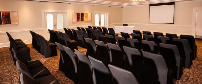 Event space at Gold Reef City Hotel with black slipcovered chairs for conferences.