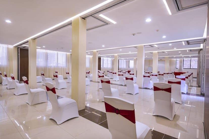 Spacious Hotel Central Park dining area with red-sashed chairs for meetings or weddings.