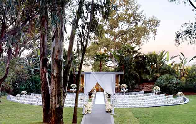 Outdoor wedding venue with floral arrangements and elegant aisle for intimate ceremonies.