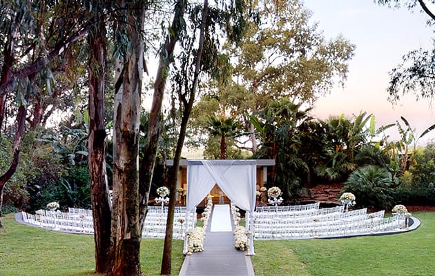 Outdoor wedding venue with floral arrangements and elegant aisle for intimate ceremonies.