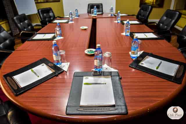 Conference room setup at Oak Place Hotel, featuring an oval table for meetings and events.
