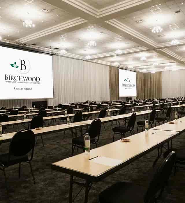 Conference room at Birchwood Hotel with rows of tables for business meetings.