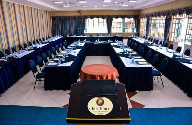 Conference room with U-shaped seating in Oak Place Hotel, ideal for corporate events and workshops.