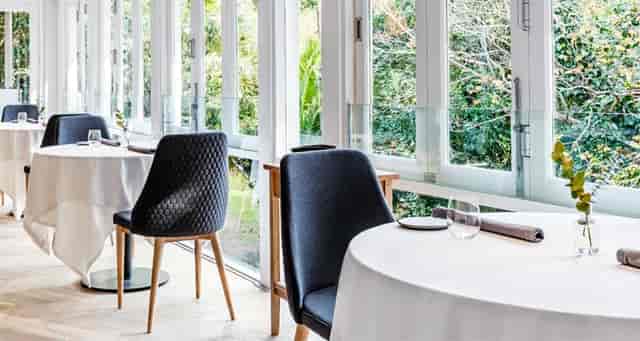 Elegant restaurant dining space with large windows, ideal for meetings and events.