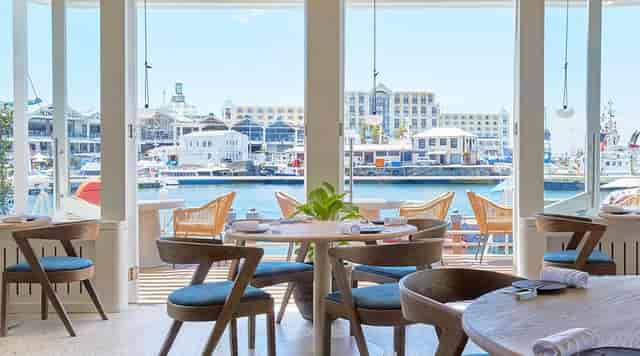 Bright waterfront restaurant with modern decor, ideal for events and gatherings.