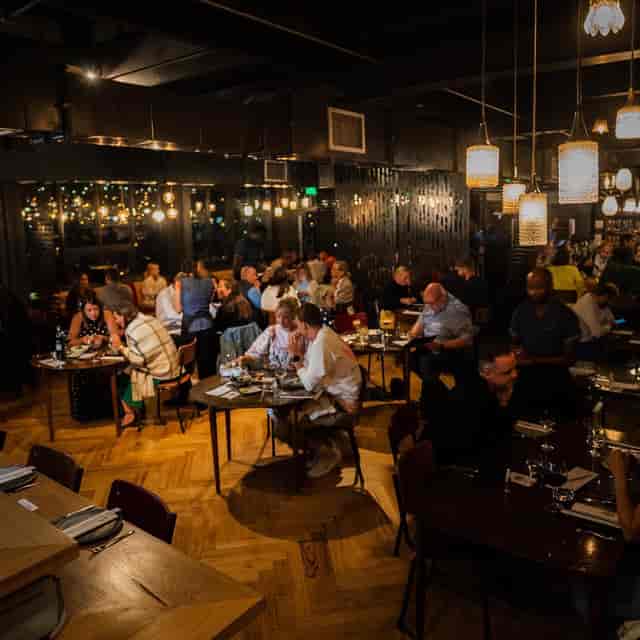 Bustling Potluck Club restaurant, warm lighting, perfect for networking events and dinners.