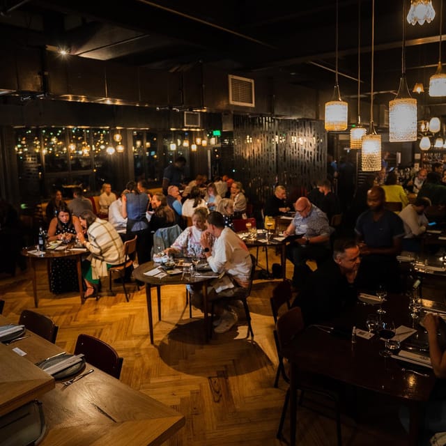 Bustling Potluck Club restaurant, warm lighting, perfect for networking events and dinners.