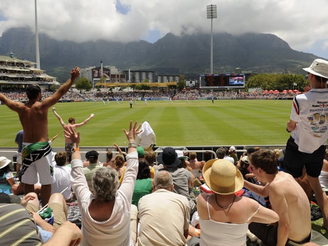 Cricket match at Cape Town Cricket Club with fans and mountain backdrop, ideal for events.