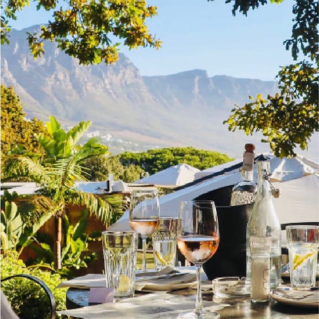 Elegant outdoor lunch setting with glassware in scenic mountain backdrop, ideal for events.