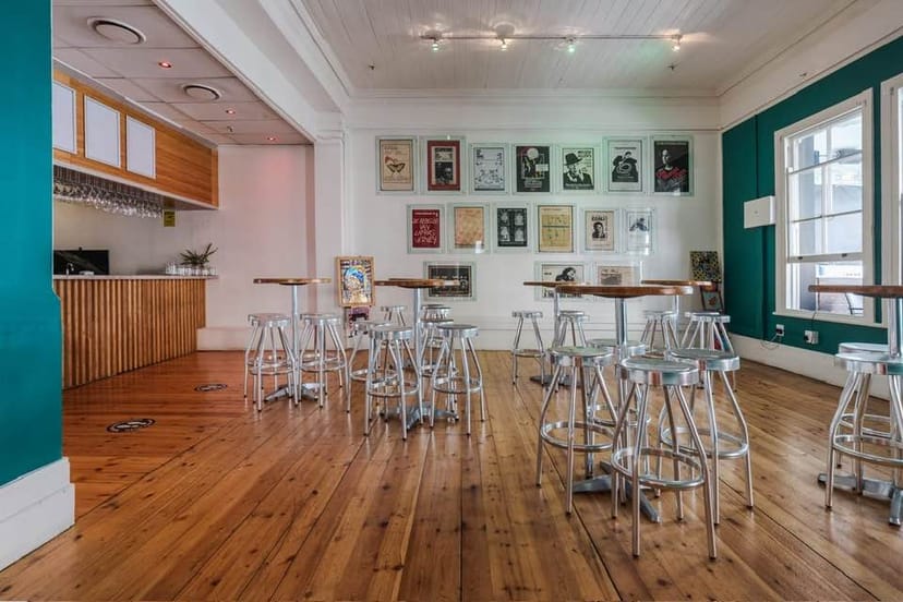 Stylish balcony event space in The Wave Theatre with vibrant teal walls, ideal for gatherings.