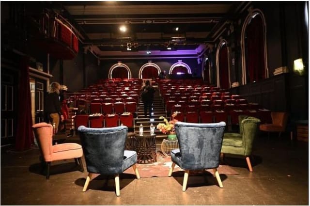 Intimate exhibition area with plush seating for panel discussions and events at The Wave Theatre.