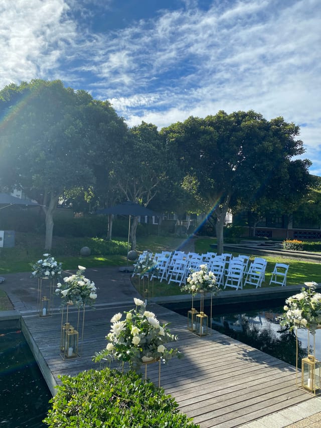 Outdoor garden venue with white chairs, perfect for weddings or special events.