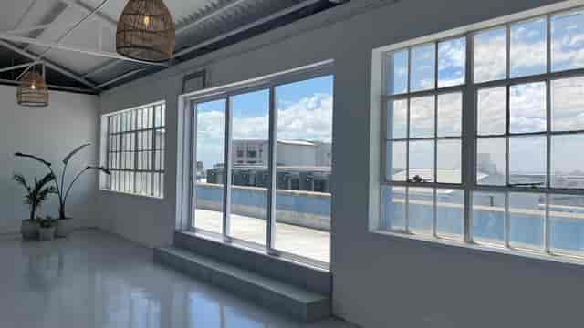 Bright rooftop event space with large windows for corporate meetings and workshops.