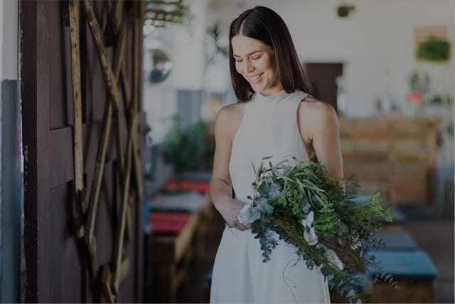Poised individual in elegant attire at Colorbox Studios outdoor courtyard event.