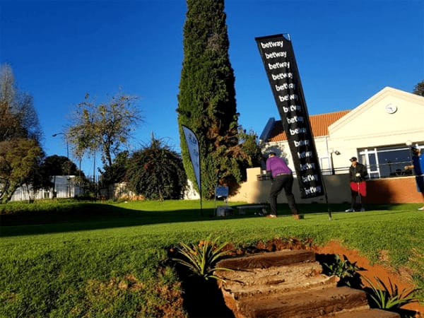 "Outdoor golf event at Observatory Golf Club with vibrant atmosphere and brand flag."