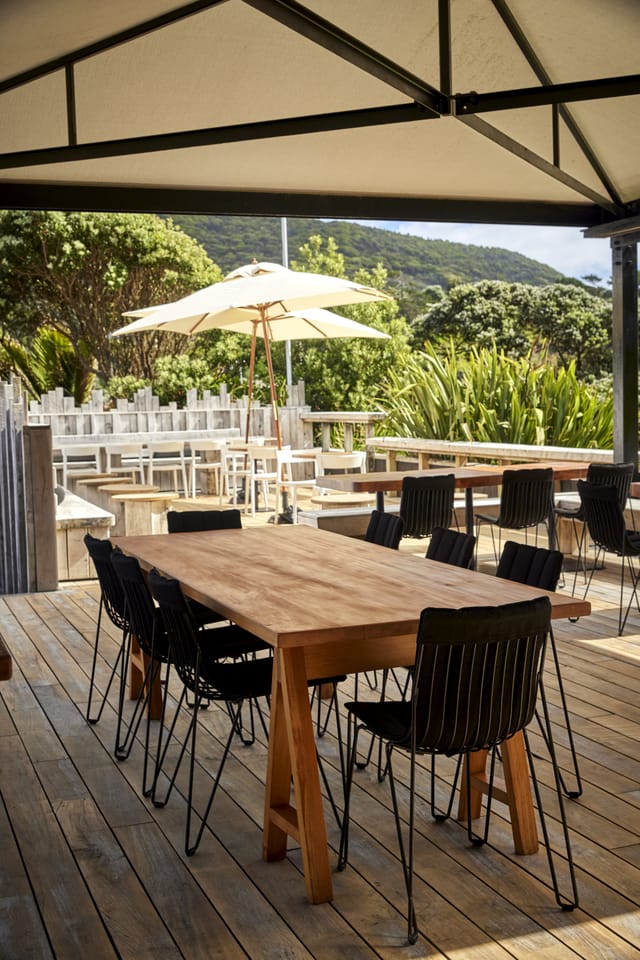 Outdoor dining area with wooden table, modern chairs for al fresco gatherings.