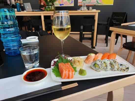 Upscale sushi plate with wine, perfect for corporate lunches and networking events.