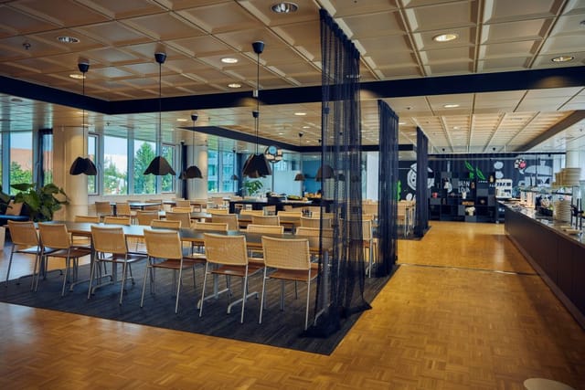 Modern meeting venue with natural light, perfect for networking and dining events.