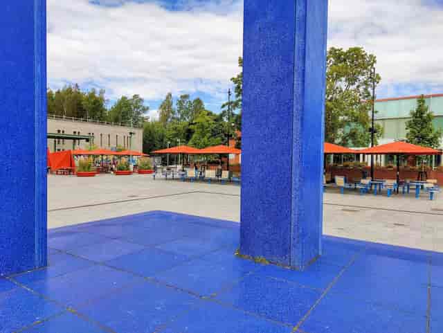 Vibrant outdoor event space with blue pillars, ideal for meetings and gatherings.
