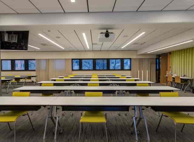 Modern meeting space in Kuntatalo, featuring yellow chairs for events and discussions.