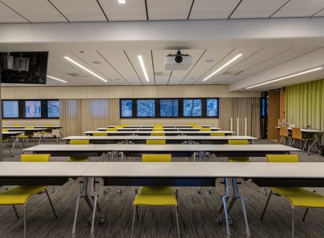 Modern meeting space in Kuntatalo, featuring yellow chairs for events and discussions.