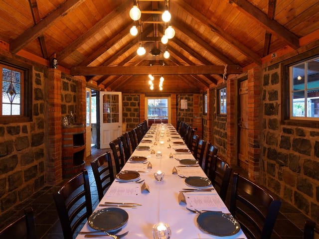 Rustic dining area with long table, ideal for events and intimate gatherings in La Maison Restaurant.