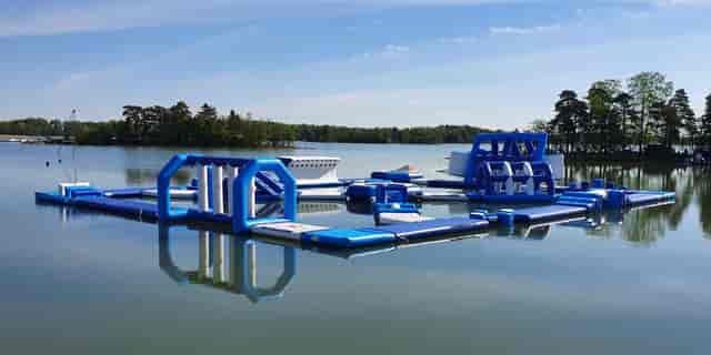Vibrant inflatable water attraction on serene lake for unique corporate retreats and team-building.