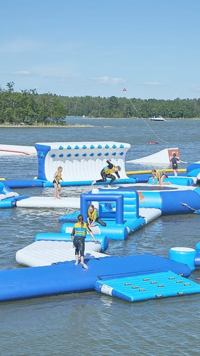 Vibrant inflatable water park at Laguuni Mustikkamaa for team-building events.