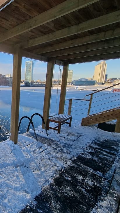 Wooden platform overlooking frozen water at Laguuni Mustikkamaa for winter networking events.