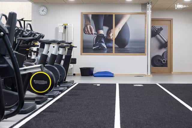 Modern fitness meeting room with exercise machines for wellness events and team-building activities.