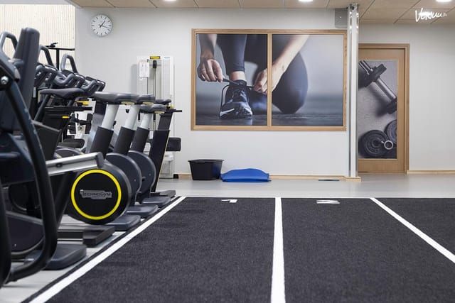 Modern fitness meeting room with exercise machines for wellness events and team-building activities.