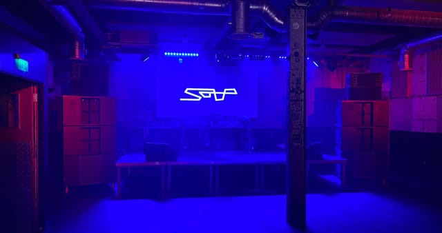 Intimate nightclub event space in SOUP Manchester with vibrant blue lighting and stage.