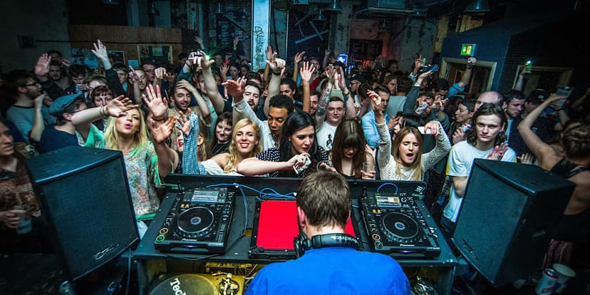 Vibrant Manchester nightclub with DJ energizing a crowded dance floor event.
