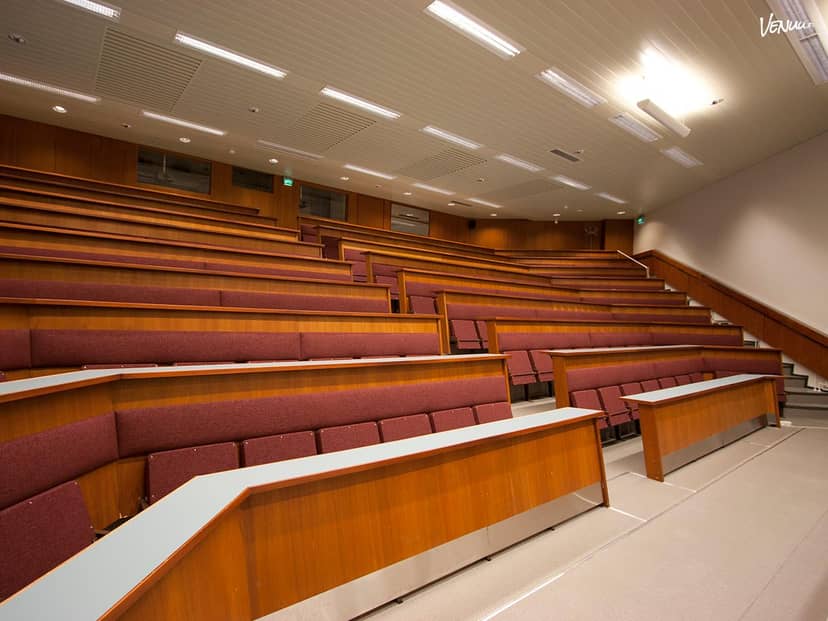 Modern auditorium with tiered seating in Hotel Haaga Central Park for conferences and lectures.