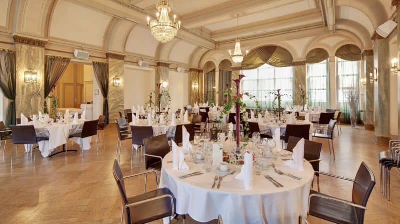 Elegant banquet hall with round tables for weddings and corporate events at Kellari restaurant.