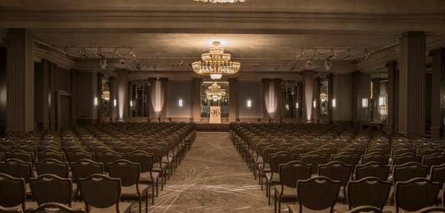 Elegant Marriott Bonvoy event hall with plush seating for formal conferences and seminars.
