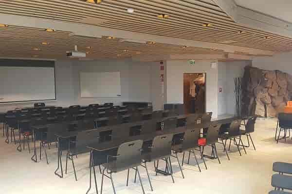 Versatile Dipoli meeting space with stone feature, perfect for workshops and presentations.