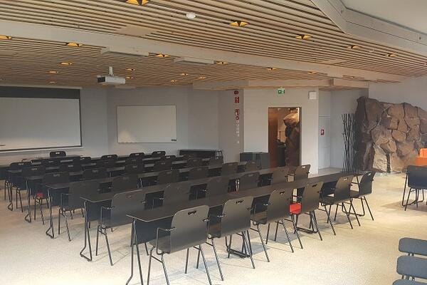 Versatile Dipoli meeting space with stone feature, perfect for workshops and presentations.