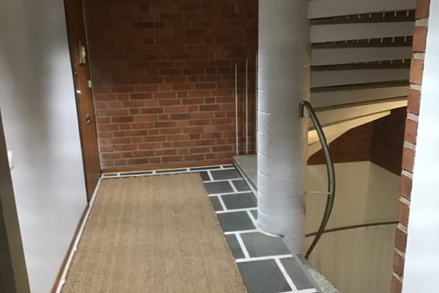 Lounge area with brick walls and staircase, perfect for networking events in Munkkiniemi.