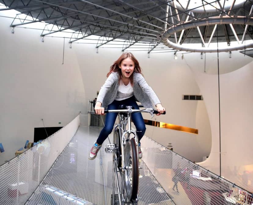 Dynamic exhibition area at Heureka with a child riding a bike, ideal for innovative events.