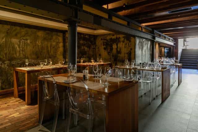 Modern restaurant interior with wooden tables, ideal for private events and intimate dinners.