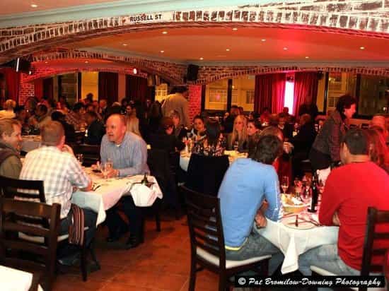 Function room at The Rockwell Dinner Theatre, lively dining event with warm lighting.