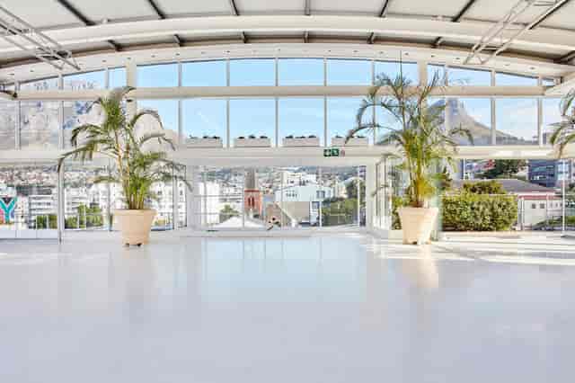 Bright rooftop event space with large windows, perfect for corporate meetings and social gatherings.