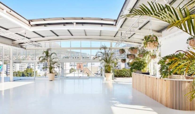 Bright rooftop event space with large windows, ideal for seminars and networking.