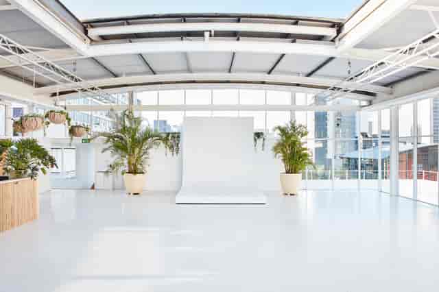 Bright indoor rooftop event space with large windows for corporate meetings and social gatherings.