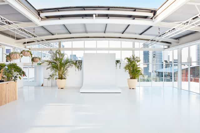 Bright indoor rooftop event space with large windows for corporate meetings and social gatherings.