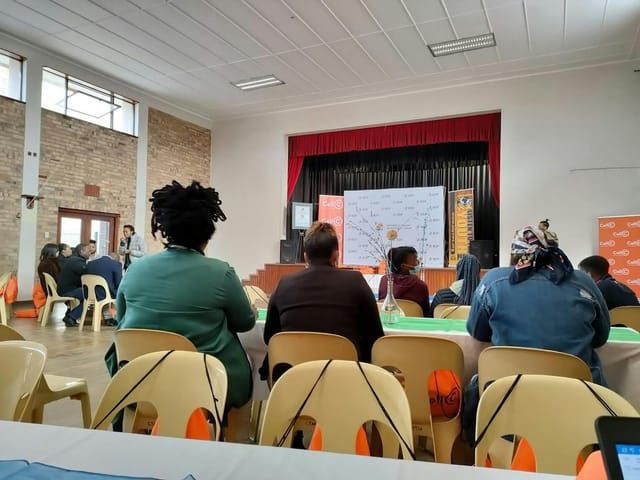 Indoor seminar in Observatory Recreation Centre with attentive attendees and presentation setup.