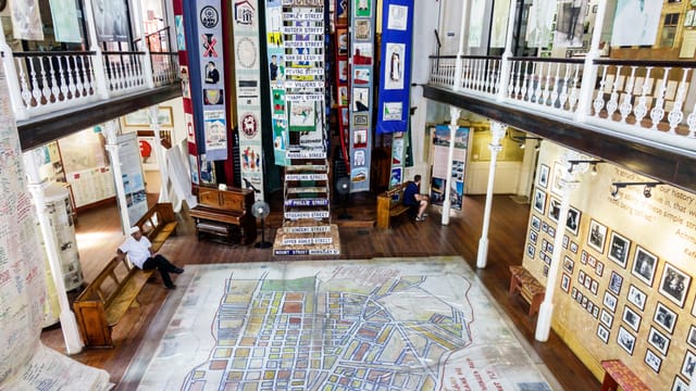 "Spacious exhibition hall with art-adorned staircase, ideal for creative workshops and events."