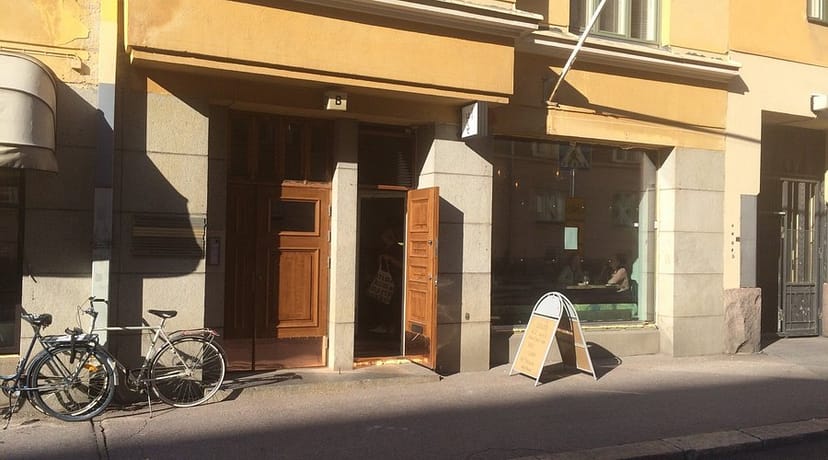Modern restaurant entrance with wooden doors, ideal for meetings and events.